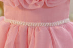 Close-up of the pearl belt at the waist of the dusty rose girls formal dress.