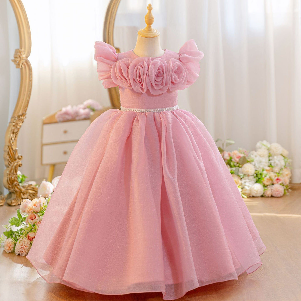 Dusty rose tulle flower girl dress with a pearl belt and full ball skirt, front view, for a wedding.