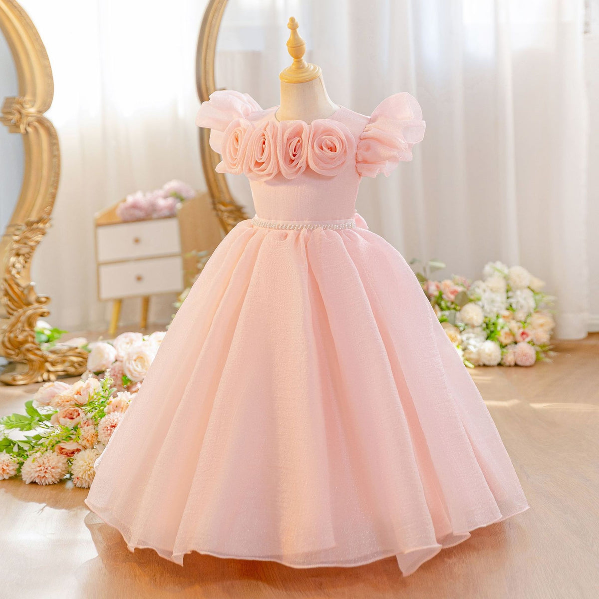 Shrimp pink tulle flower girl dress with rose trimmed flutter sleeves, front view, for a birthday party.