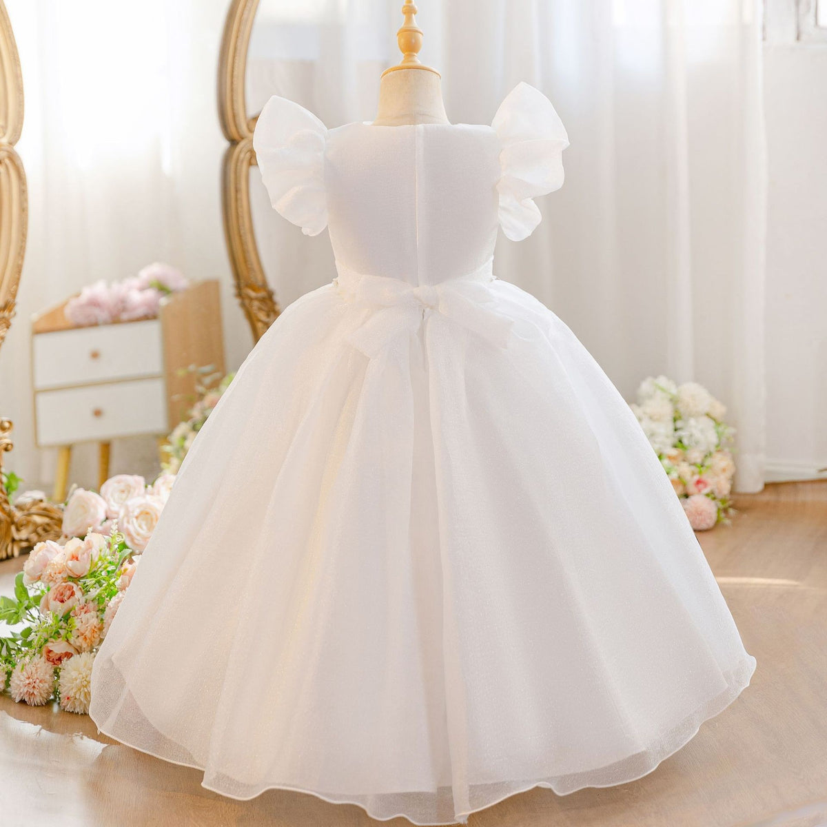 Back view of the white flower girl dress showing the bow and the full skirt.