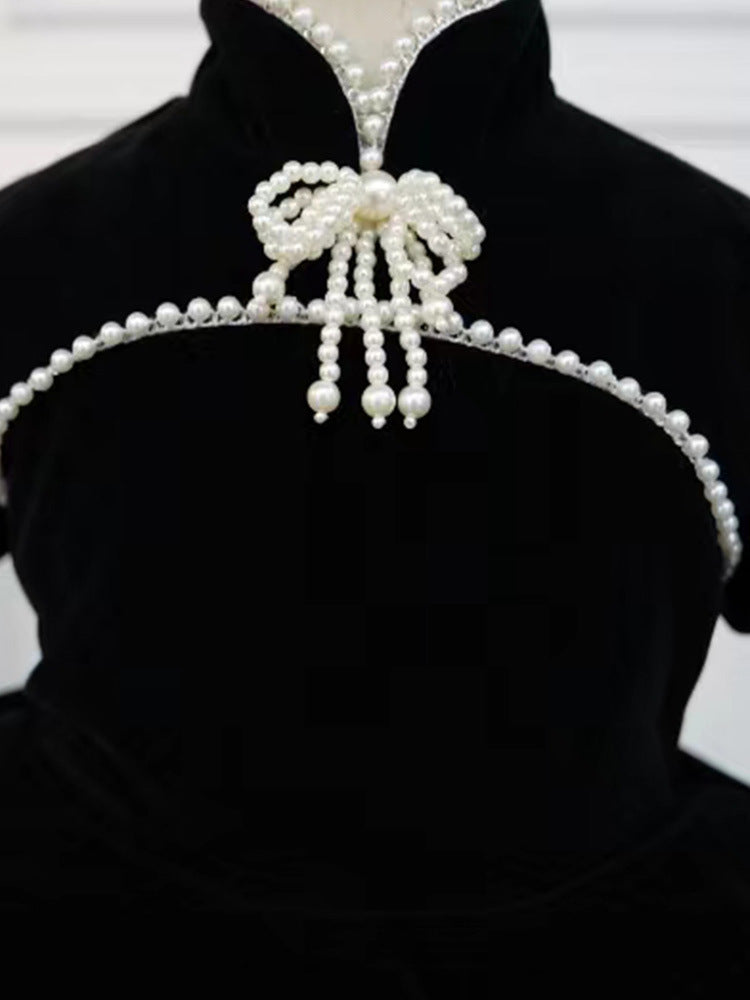 Close-up of the pearl bow collar with pearl tassels on a black velvet girls dress, designed for birthday parties.