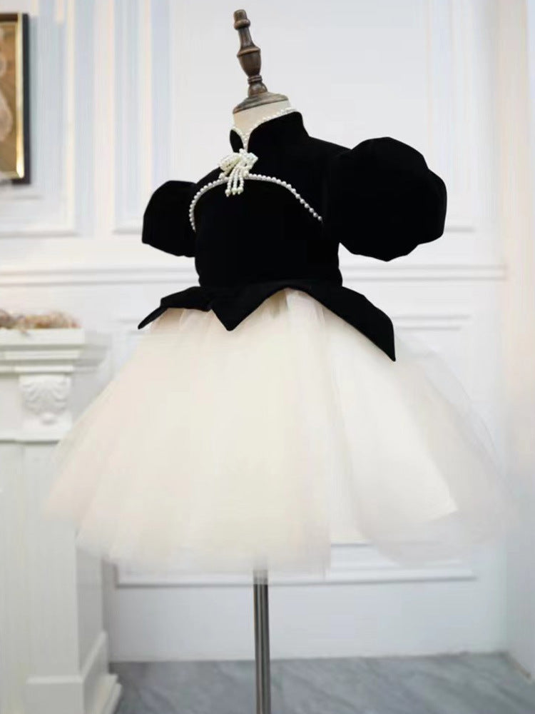 Black and ivory velvet girls dress with puff sleeves and pointed peplum over a tulle tutu, designed for birthday parties.