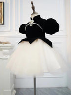Black and ivory velvet girls dress with puff sleeves and pointed peplum over a tulle tutu, designed for birthday parties.
