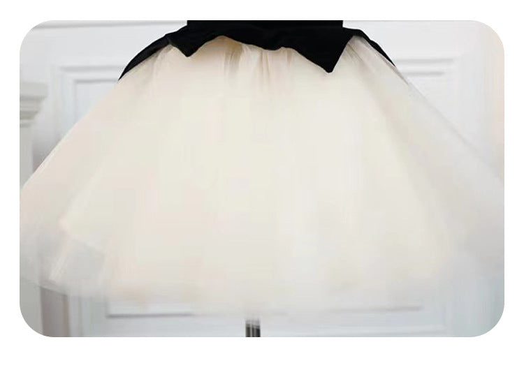 Detail of the layered ivory tulle tutu skirt on a black velvet girls dress, designed for birthday parties.
