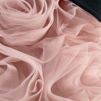 Close-up of the rolled blush pink tulle rosettes on the skirt of this princess dress for girls.