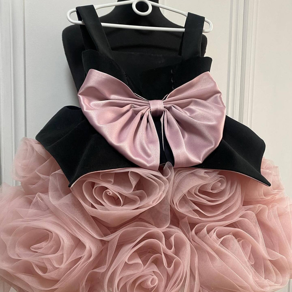 Black and pink rosette tulle birthday girls dress with a velvet bodice and pink satin bow, front view, for a birthday party.