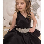 Close-up of the rhinestone beaded belt and the V neckline on the black satin gown.