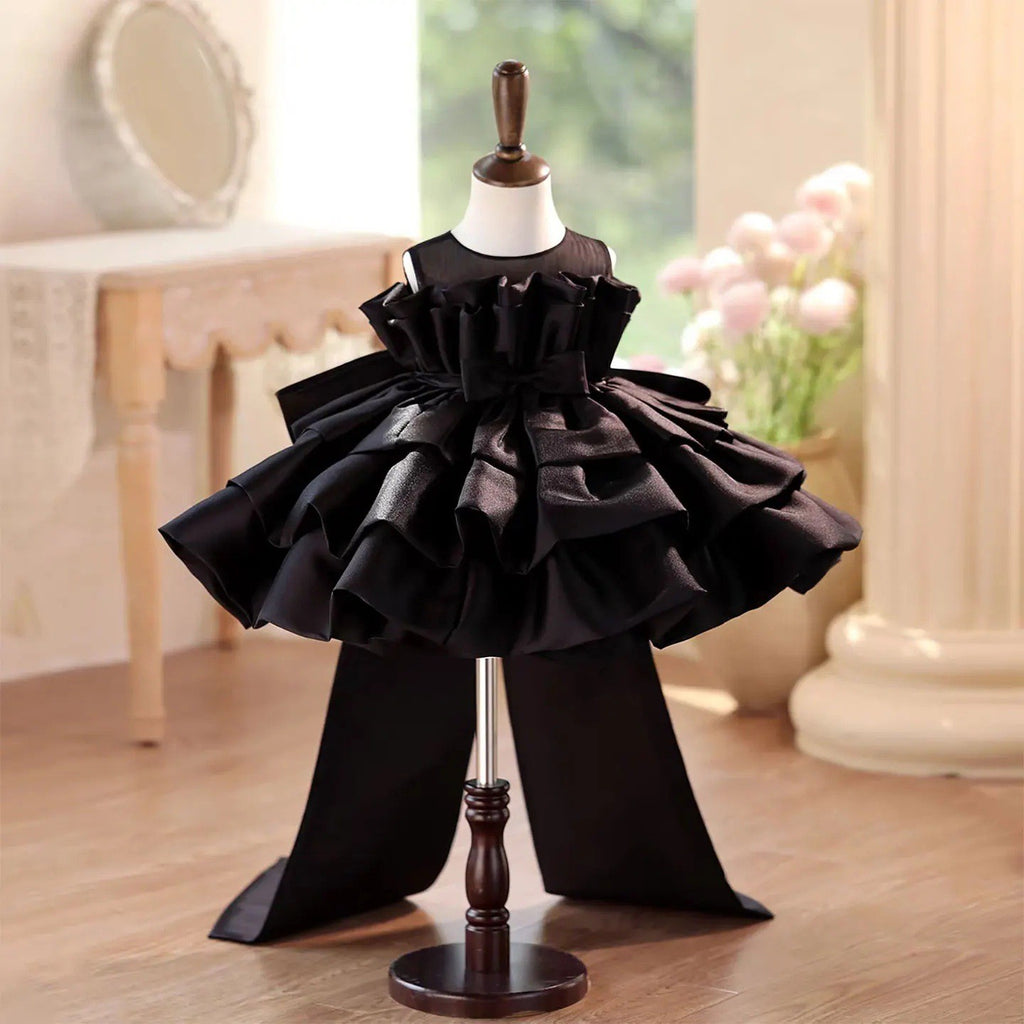 Black satin girls party dress with a ruffle collar and tiered cake skirt, front view, for a birthday party.