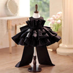 Black satin girls party dress with a ruffle collar and tiered cake skirt, front view, for a birthday party.