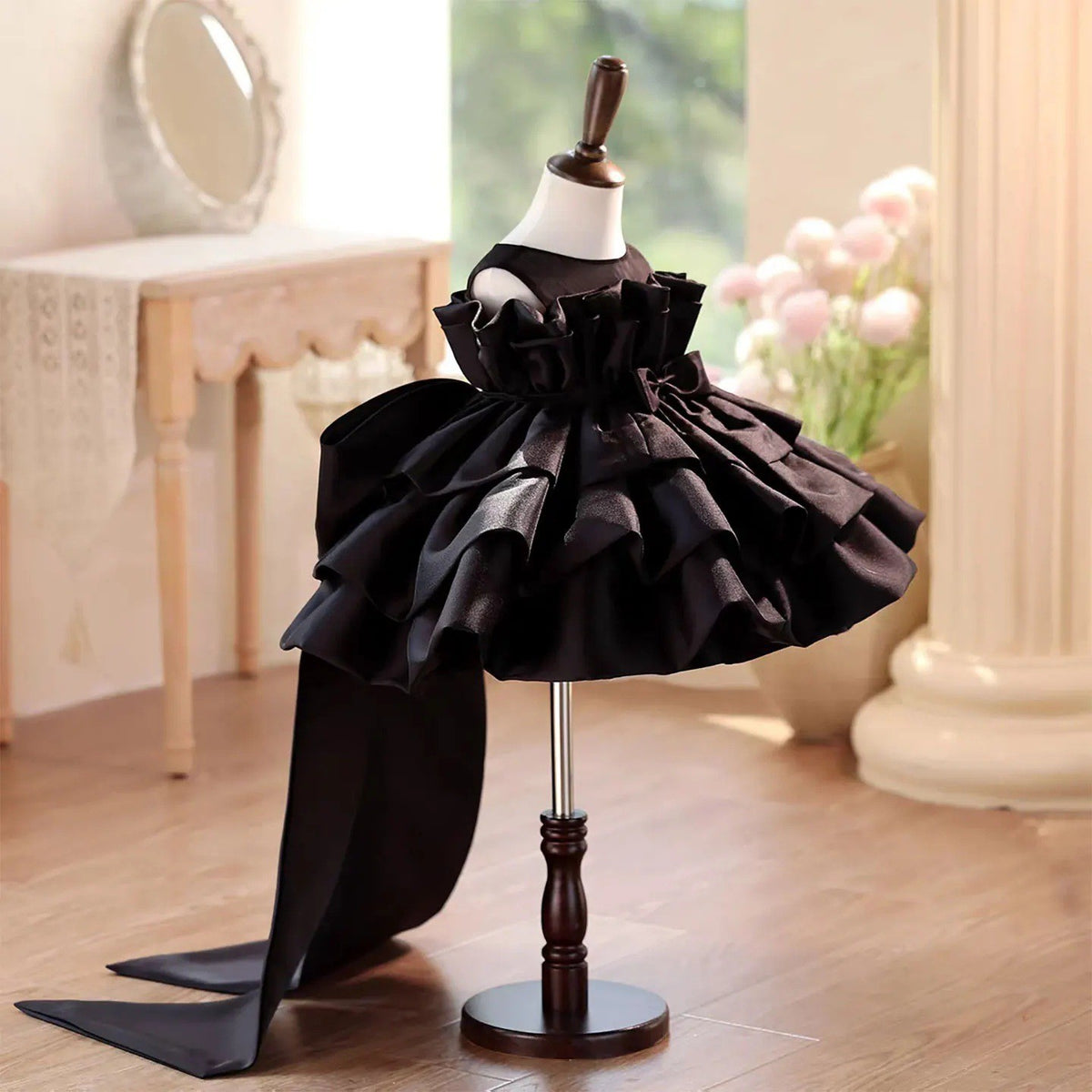 Black satin party dress for girls showing the standing ruffle collar and sheer yoke, angled front view.