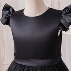 Close-up of the satin bodice, round neckline and flutter sleeve on the black girls dress.