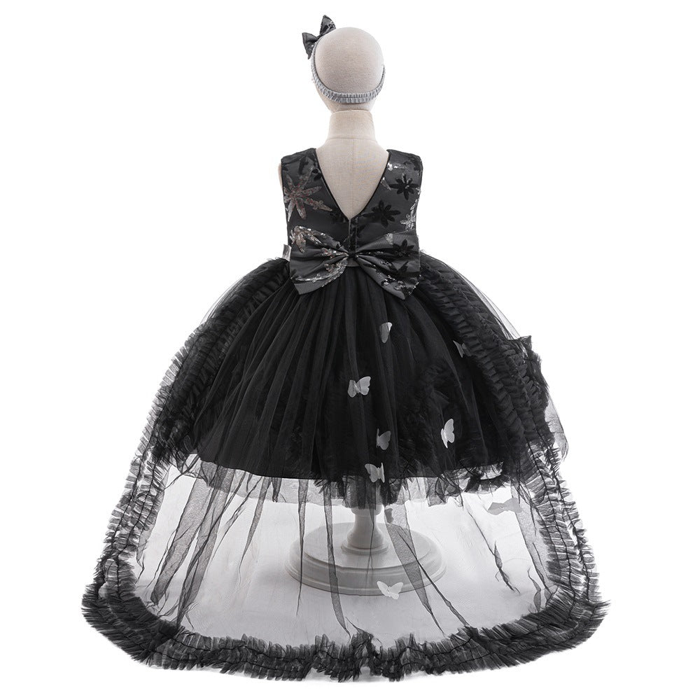 Back view of the black sequin tulle girls gown with V-back, oversized sequin bow and sheer ruffled train, designed for Halloween parties.