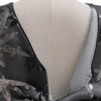 Close-up of the V-back with zipper closure and sequin embroidery on the black girls gown.