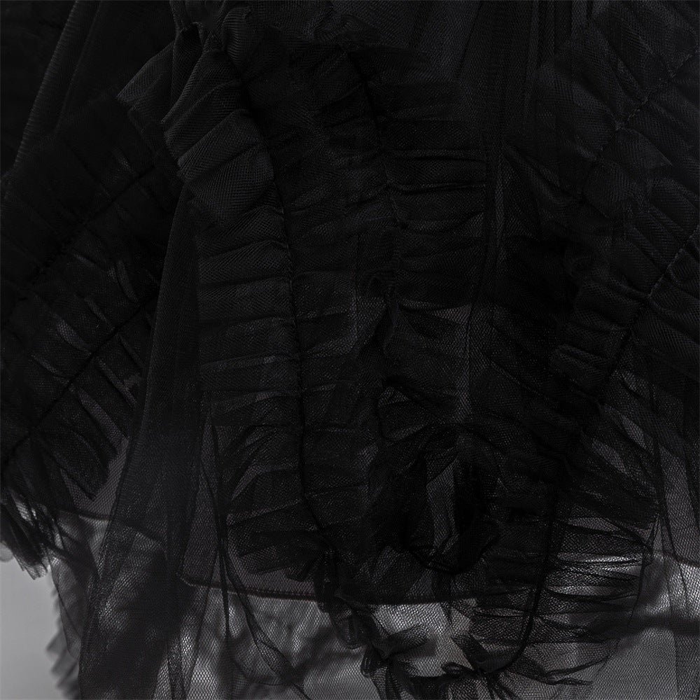 Close-up of the ruffled black tulle trim along the train of the girls gown.