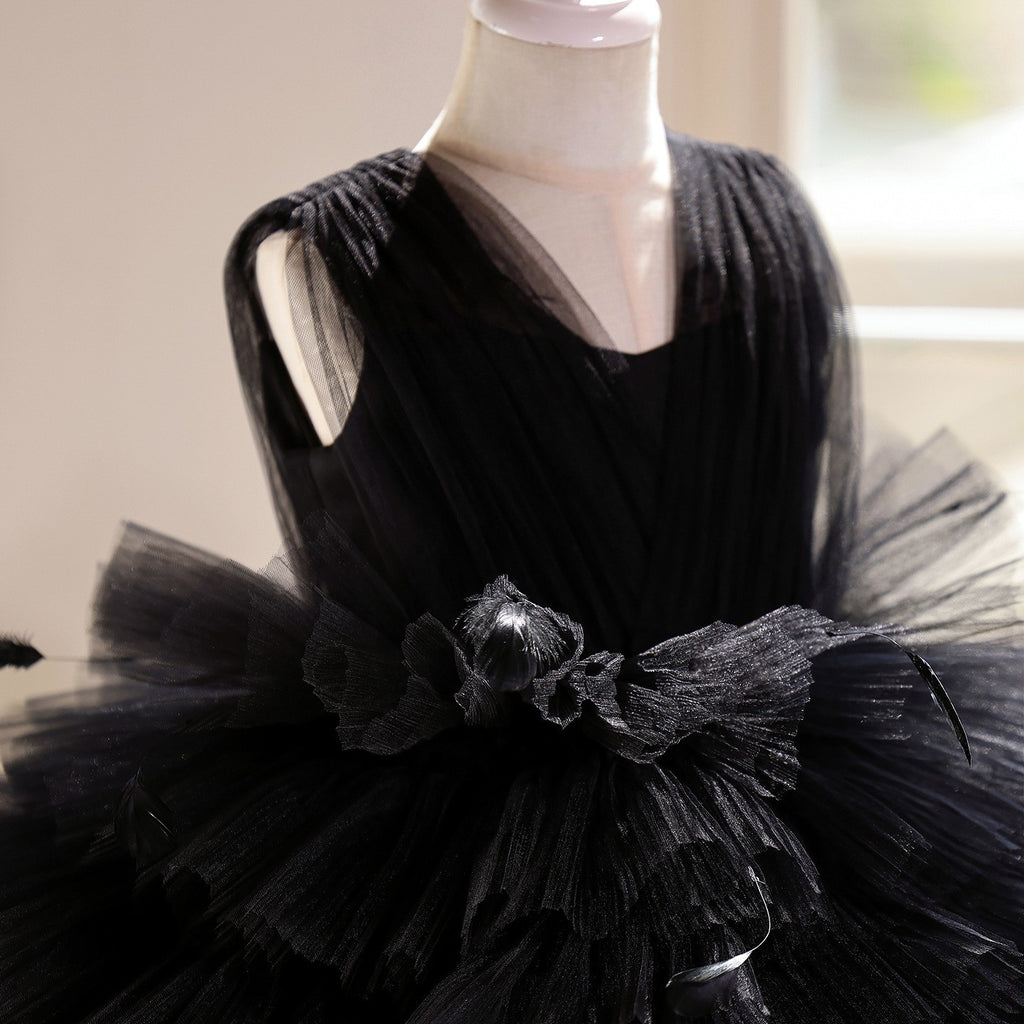 Close-up of the fabric flower cluster and feathers at the waist of the black dress for girls.
