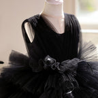Close-up of the fabric flower cluster and feathers at the waist of the black dress for girls.