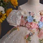 Close-up of the 3D fabric flowers with pearl centers on the blush princess dress for girls.