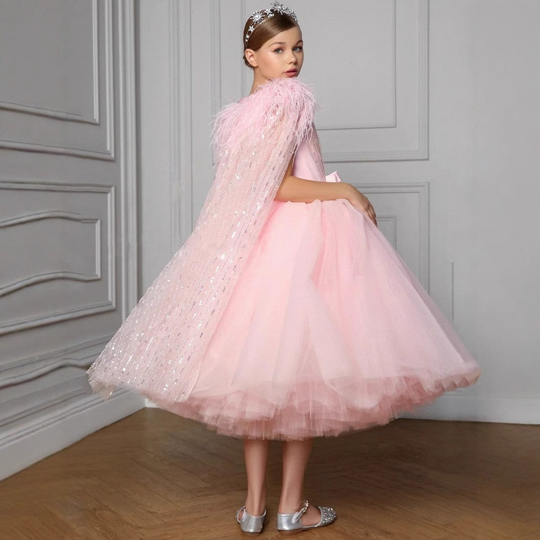 Back view of the pink tulle girls party dress showing the full tea-length skirt and the sequin cape falling from the shoulders.