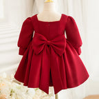 Burgundy satin girls party dress showing the oversized bow and concealed zipper at the back, back view.