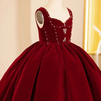 Close-up of the red and clear rhinestones and crystal flower appliques on the burgundy velvet flower girl dress.