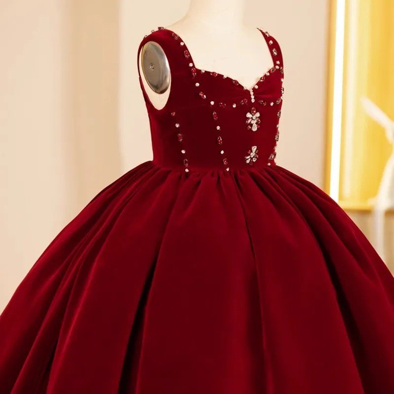 Close-up of the red and clear rhinestones and crystal flower appliques on the burgundy velvet flower girl dress.
