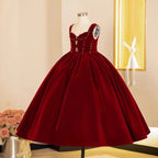 Burgundy velvet girls party dress with a deep gathered midi skirt, side view 2, for holiday celebrations.