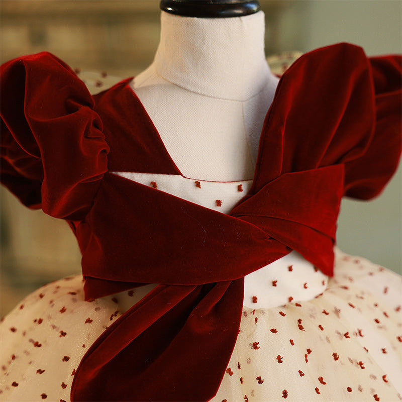 Burgundy velvet girls dress with crossed velvet bands and square neckline, designed for Christmas photos.