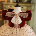 Burgundy velvet girls dress with puff sleeves and sheer dotted bow at the open back, designed for holiday events.