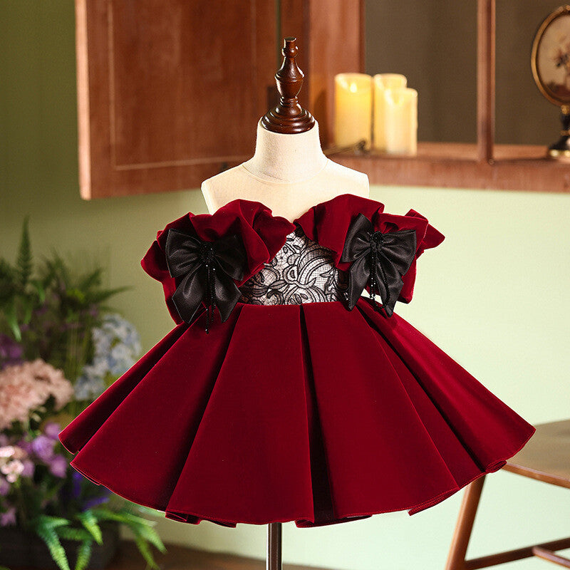 Burgundy velvet girls party dress with off-shoulder ruffle sleeves, black lace bodice and twin satin bows, front view, for birthdays and holiday parties.