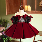 Burgundy velvet girls party dress with off-shoulder ruffle sleeves, black lace bodice and twin satin bows, front view, for birthdays and holiday parties.
