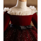 Burgundy velvet girls dress detail with ruffle shoulders, pearl trim and black bow sash, designed for Christmas.