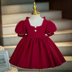 Burgundy velvet girls dress with pearl trim, puff sleeves and a full gathered skirt, designed for Christmas and winter weddings.
