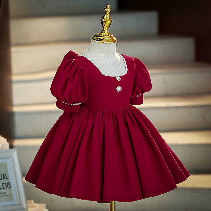 Burgundy velvet girls dress side view with puff sleeves and a full knee-length skirt, designed for holiday parties.