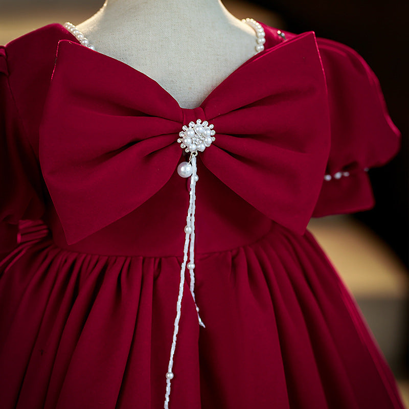 Burgundy velvet girls dress close-up of the back bow with a rhinestone-and-pearl brooch, designed for Christmas and birthdays.