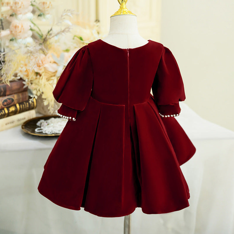 Burgundy velvet girls dress with a back zipper, pearl-trimmed cuffs and a pleated full skirt, designed for holiday parties and weddings.