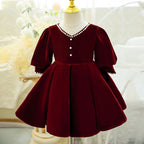 Burgundy velvet girls dress with a pearl-trimmed V-neck, long puff sleeves and a pleated full skirt, designed for Christmas and holiday parties.