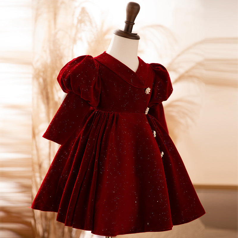 Burgundy velvet girls dress with puff sleeves and a back bow, side view, designed for Christmas and birthday parties.