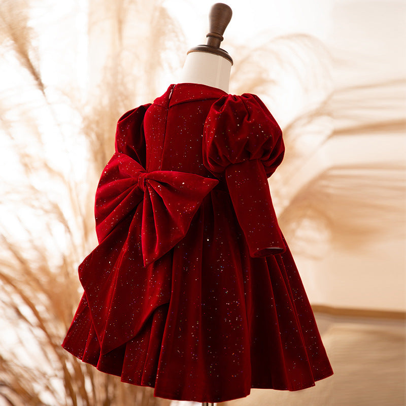 Burgundy velvet girls dress with a large velvet back bow and puff sleeves, designed for weddings and flower girls.