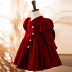 Burgundy velvet girls dress with puff sleeves and a pleated knee-length skirt, designed for holiday parties.