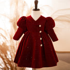 Burgundy velvet girls dress with long puff sleeves, a collared V-neck and jeweled buttons, designed for Christmas and holiday parties.