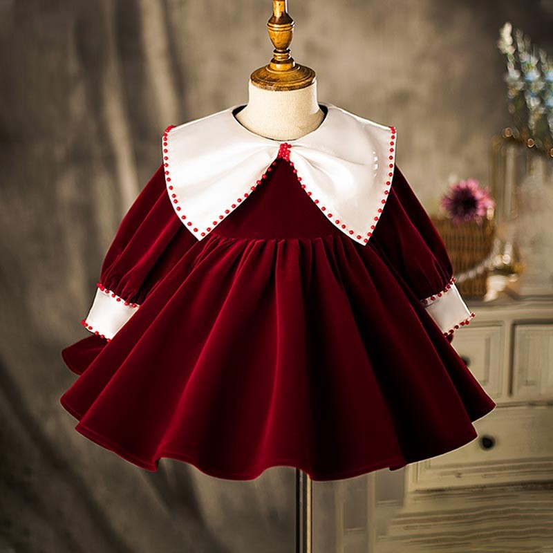 Burgundy velvet birthday girls dress with an ivory sailor collar and long sleeves, front view, for a birthday party.