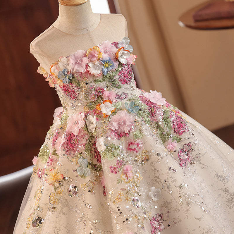 Champagne tulle girls gown with close-up 3D fabric flowers, embroidery and sequins, designed for flower girls and photoshoots.