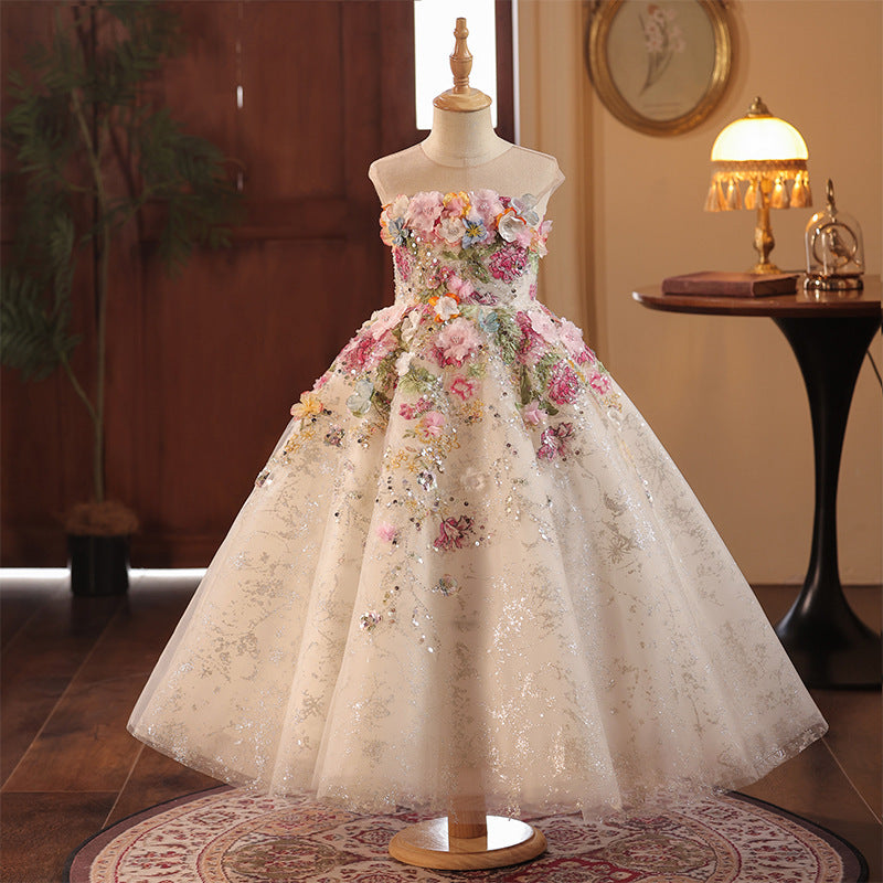 Champagne glitter tulle girls ball gown with 3D multicolor flowers and a sheer illusion neckline, designed for flower girls at weddings.