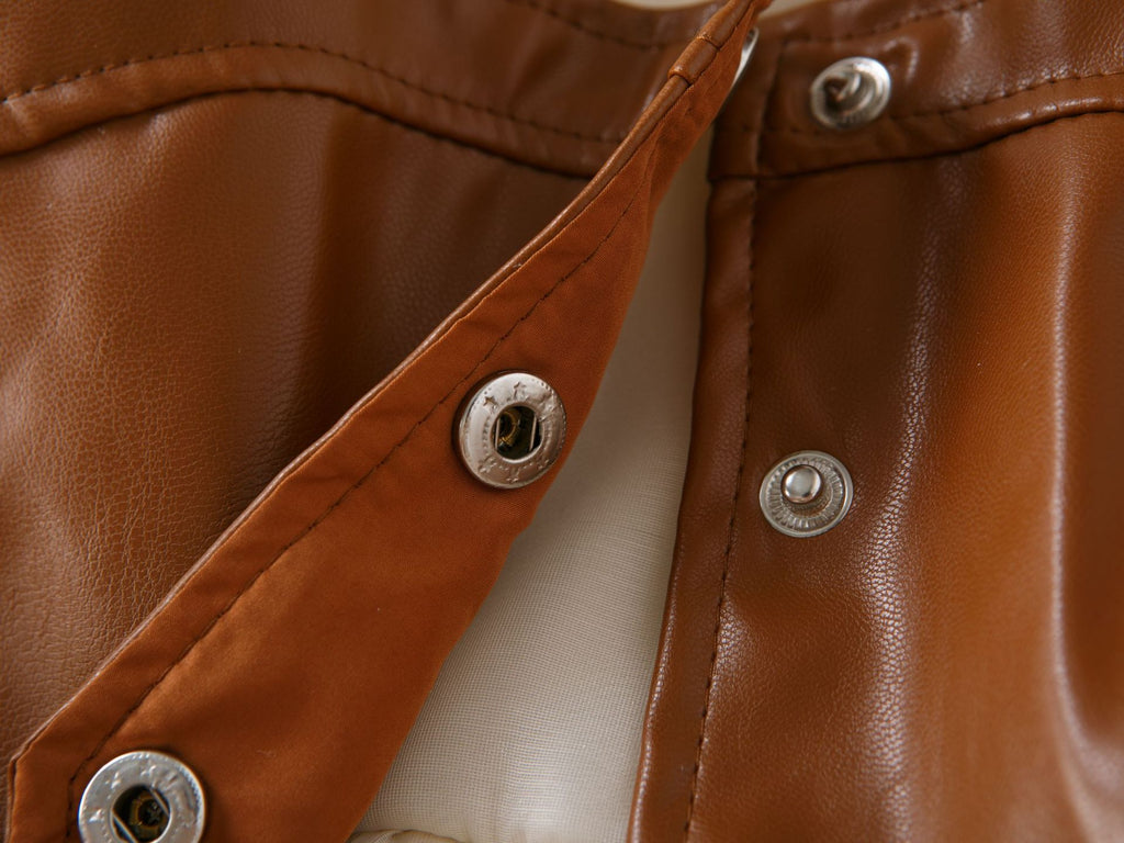 Metal snap closures inside the brown faux leather vest of the girls dress set, designed for parties.