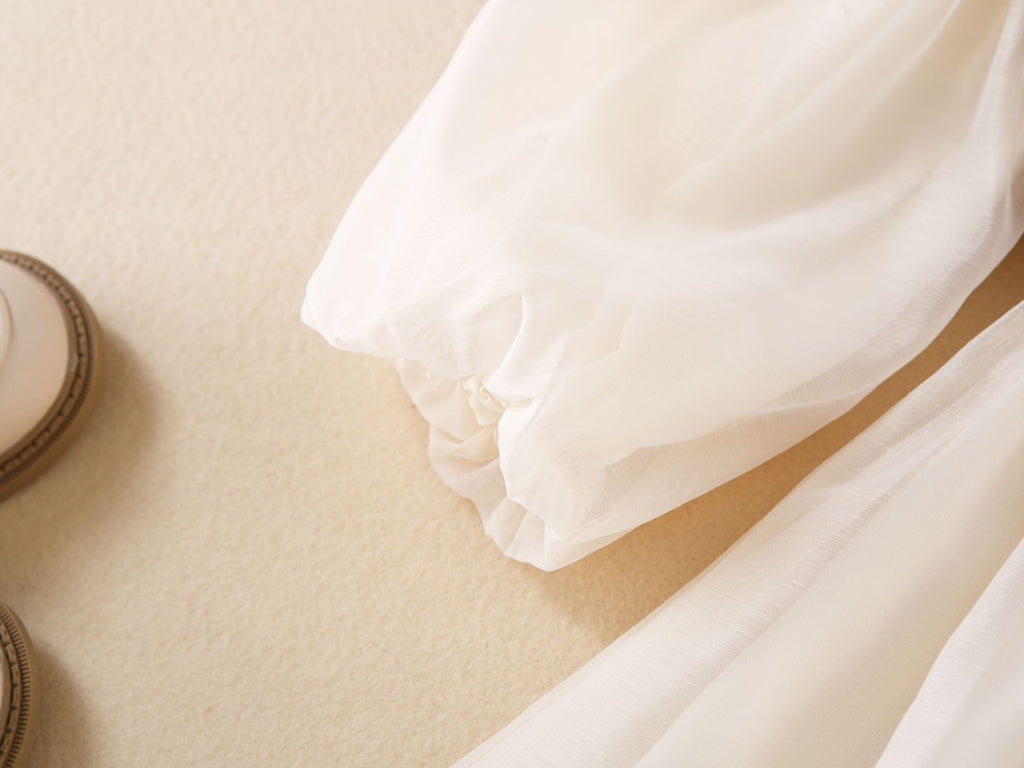 Elastic cuff of the long puff sleeve on the cream chiffon girls dress, designed for birthday parties.