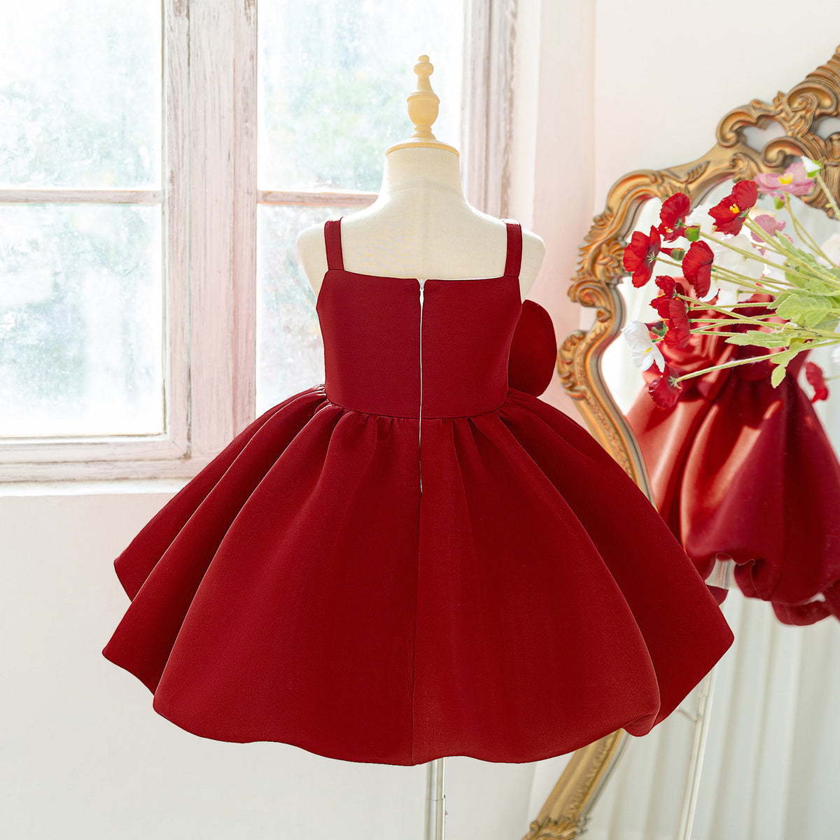 Back view of the deep red girls dress with zipper closure and full bubble skirt.