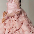 Close view of the large organza roses across the skirt of this girls formal dress.