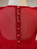 Close-up of the covered button back and sheer yoke on the red girls party dress.
