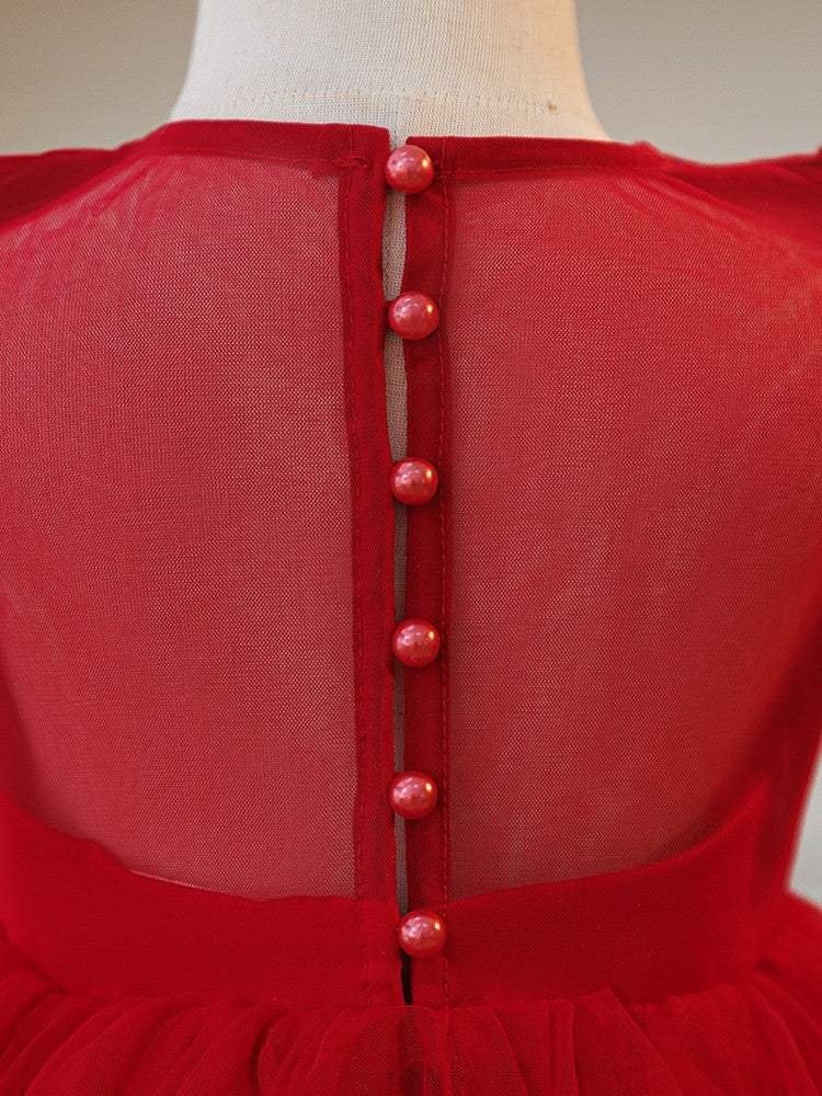 Close-up of the covered button back and sheer yoke on the red girls party dress.