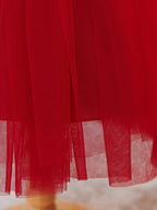 Layered tulle hem of the red flower girl dress, fabric detail.